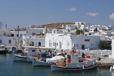 Boats in town against sky