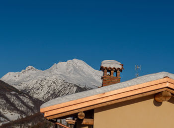 Scenic view of snowcapped mountains against clear blue sky