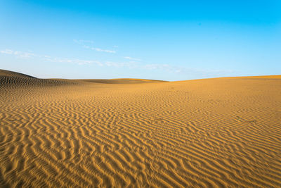 Scenic view of desert against blue sky