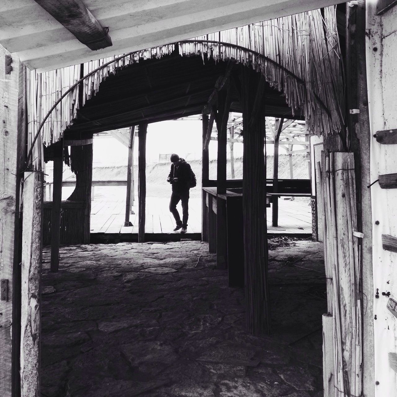 REAR VIEW OF MAN WALKING IN CORRIDOR