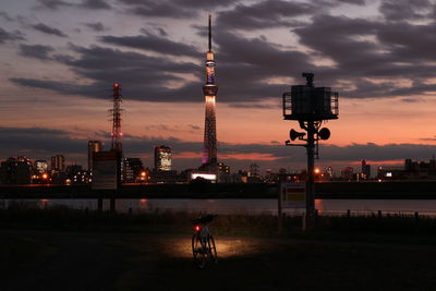 Bicycle on grass by river with tokyo sky tree against sky