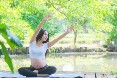 Full length of woman sitting outdoors