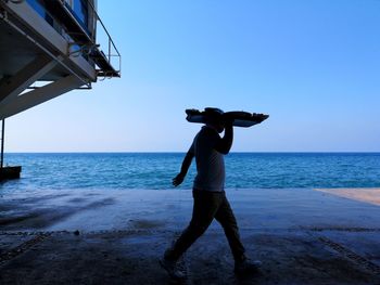 Full length of man standing on beach against clear sky