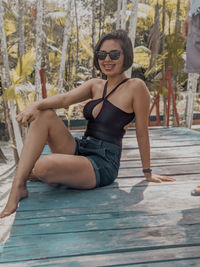 Portrait of young woman sitting on swimming pool