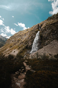 Scenic view of waterfall against sky