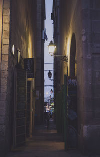 People in illuminated city against sky