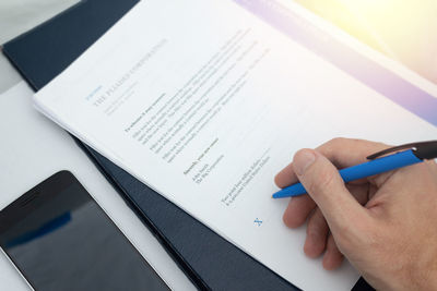 High angle view of man reading book on paper