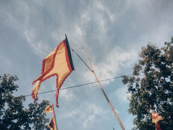 Low angle view of flags hanging against sky