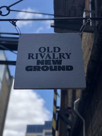 Low angle view of information sign against sky