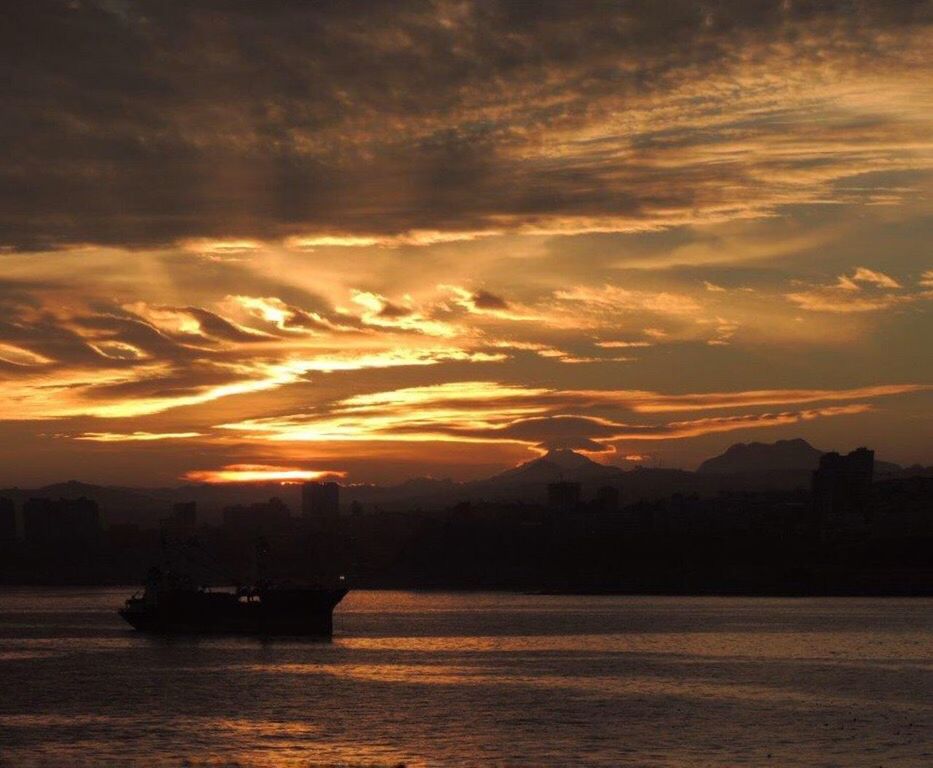 sunset, dramatic sky, cloud - sky, nautical vessel, sea, water, transportation, no people, silhouette, sky, scenics, nature, beauty in nature, waterfront, outdoors, mode of transport, tranquility, built structure, travel destinations, architecture, building exterior, city, sailing, sailing ship, day