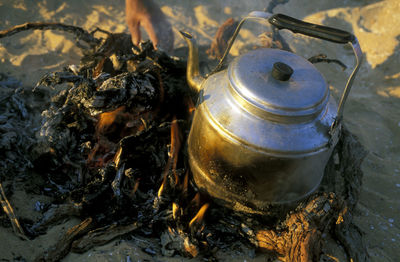 Close-up of tea kettle on fire log