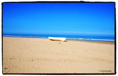 Scenic view of beach against blue sky