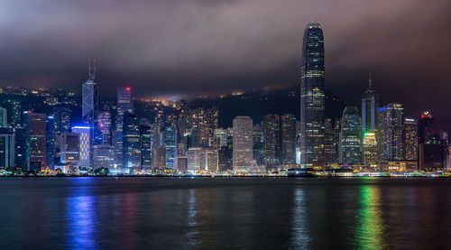 Illuminated buildings in city against sky at night