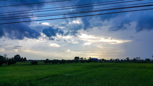 Scenic view of field against cloudy sky