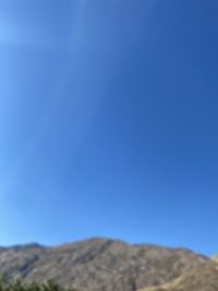 Low angle view of mountain against clear blue sky