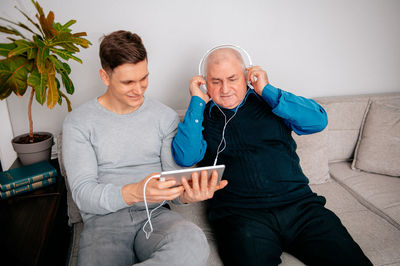 Man spending leisure time with grandfather at home