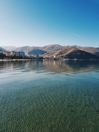 Scenic view of lake against clear blue sky