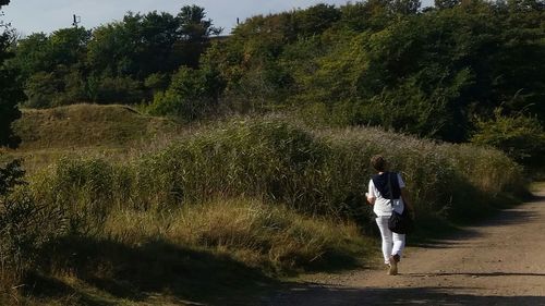 Rear view of woman walking on landscape