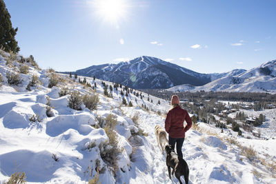 A woman walking with her dogs on a crisp winter morning.