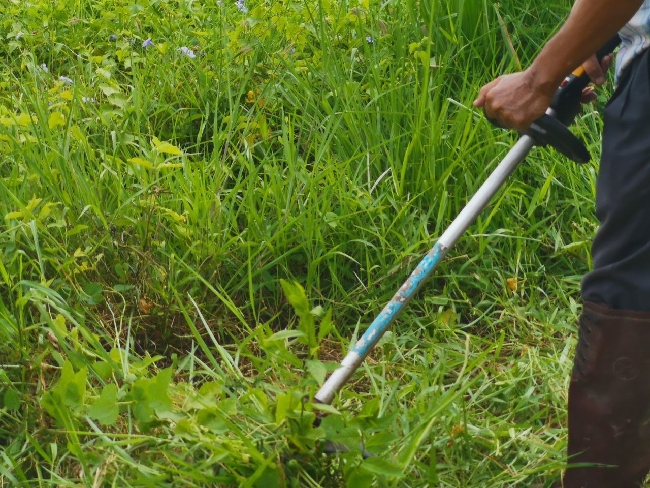 MAN WORKING ON GRASS