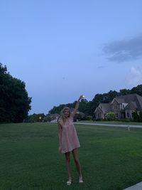 Full length of woman standing on field against sky