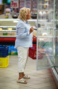 Side view of senior woman buying groceries in supermarket