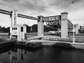 Bridge over river in city against sky