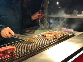 High angle view of man preparing food on barbecue grill