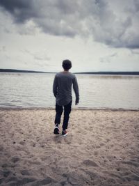 Full length rear view of man standing on beach