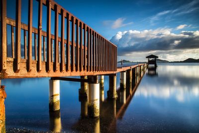 Pier over river against sky