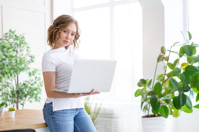 Young woman using mobile phone at home
