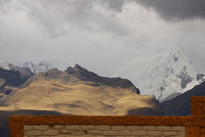 Scenic view of snowcapped mountains against cloudy sky
