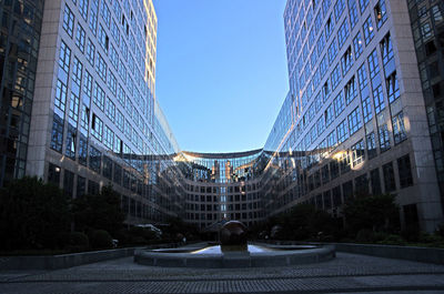 Modern buildings in city against clear blue sky