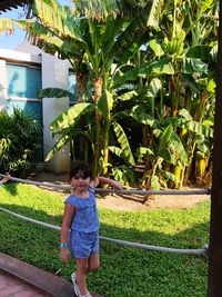 Full length of girl standing by plants