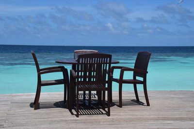 Chairs on beach against sky