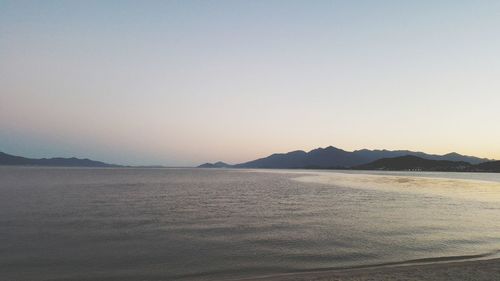 Scenic view of lake against clear sky during sunset