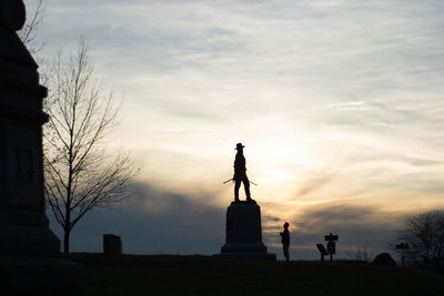 Low angle view of silhouette statue against sky during sunset