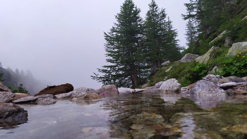 Scenic view of rocks by lake against sky