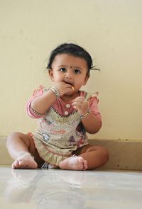 Portrait of cute girl against wall