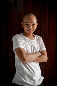 Portrait of smiling boy standing against door