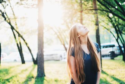 Thoughtful beautiful woman looking up on field