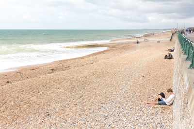 Woman standing on beach against sky