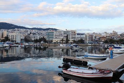 Boats moored in river against buildings in city