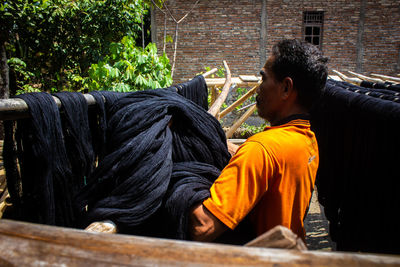  the craftsmen do  dyeing process of the fabric lurik in tringsing village,  java, indonesia