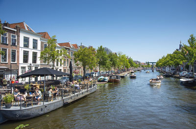 Boats in canal against clear blue sky