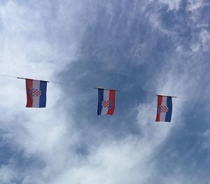 Low angle view of flags hanging against sky