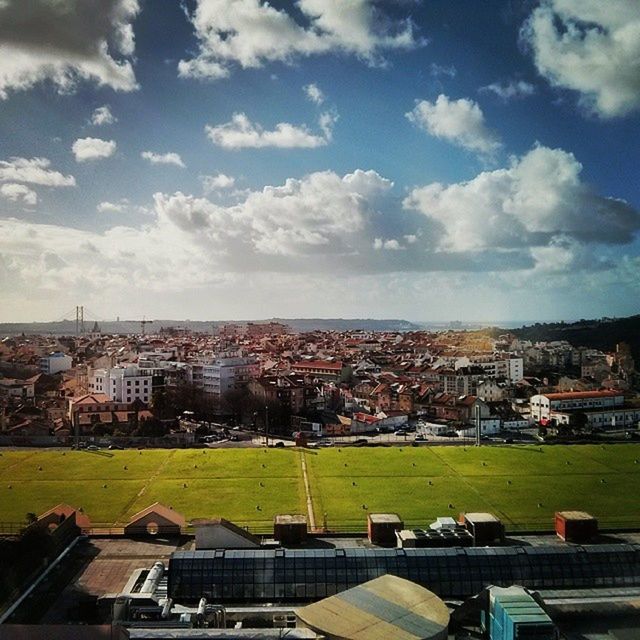 building exterior, architecture, built structure, cityscape, sky, city, high angle view, crowded, cloud - sky, residential district, grass, residential building, residential structure, landscape, cloud, day, cloudy, tree, house, outdoors