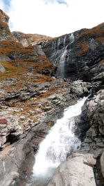 Scenic view of waterfall against sky
