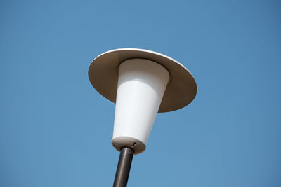 Low angle view of street light against blue sky