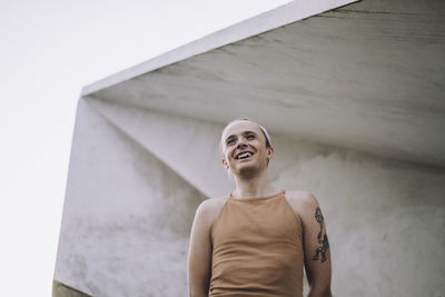 Low angle view of non-binary person standing against wall